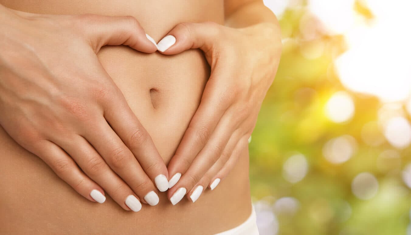 Paciente do sexo feminino com as mãos ao redor do umbigo, formando um coração