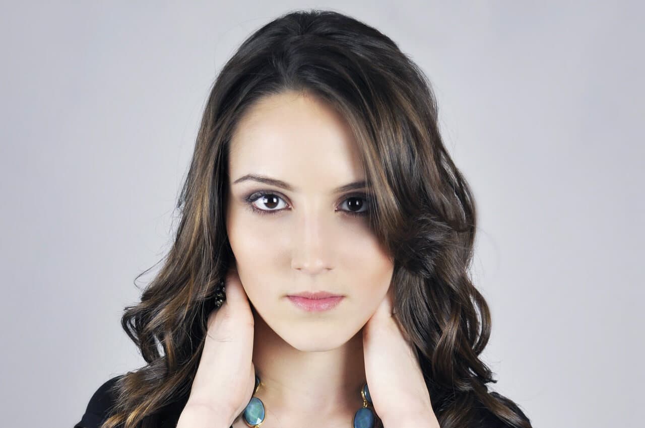 Mulher morena com as mãos na nuca
