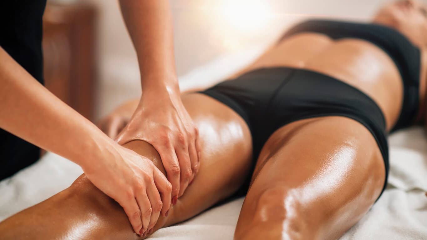 Mulher recebendo massagem de drenagem linfática nas pernas