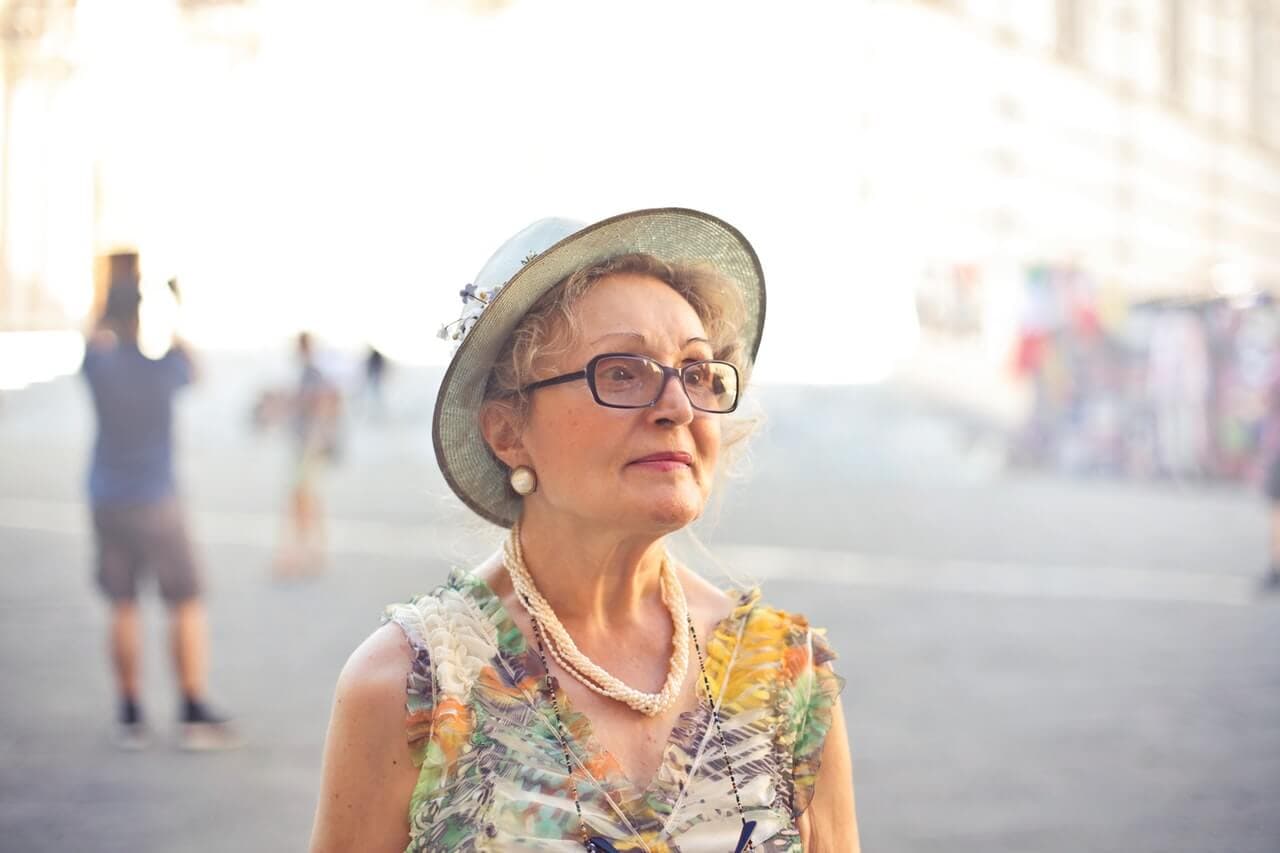 Mulher mais velha com o rosto com sinais de envelhecimento