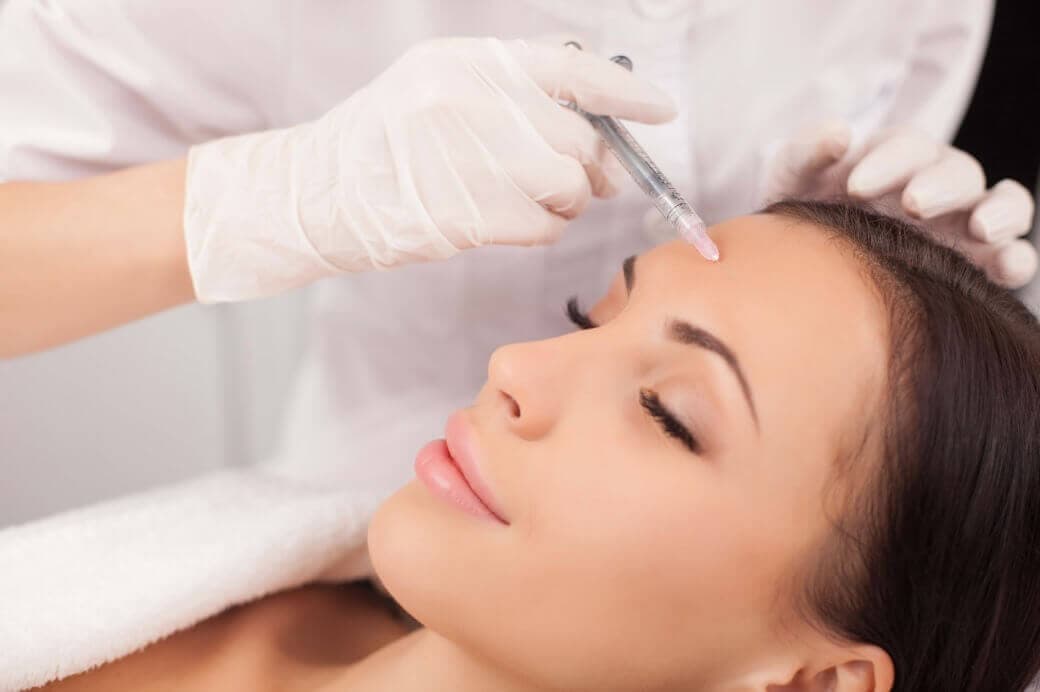 Mulher fazendo aplicação de botox no rosto