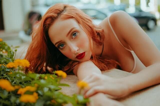 Mulher apoiada em mesa perto de flores