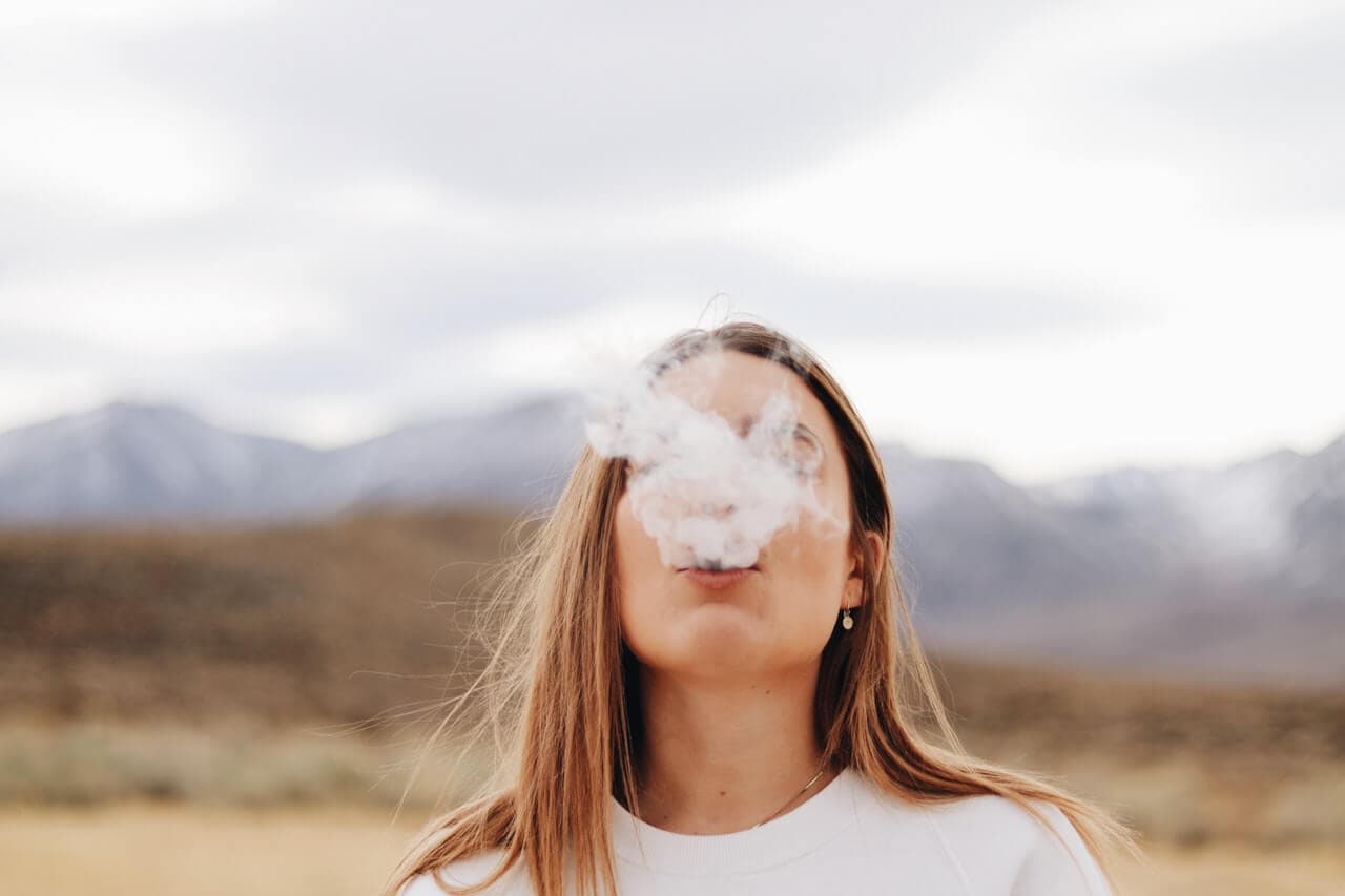 Mulher soltando fumaça de cigarro