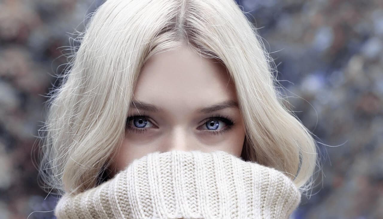 Mulher com roupa de frio cobrindo metade do rosto