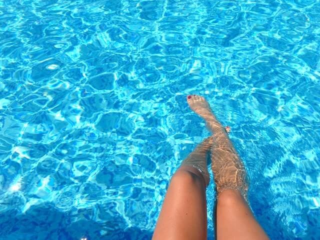 Coxas de mulher na beira da piscina