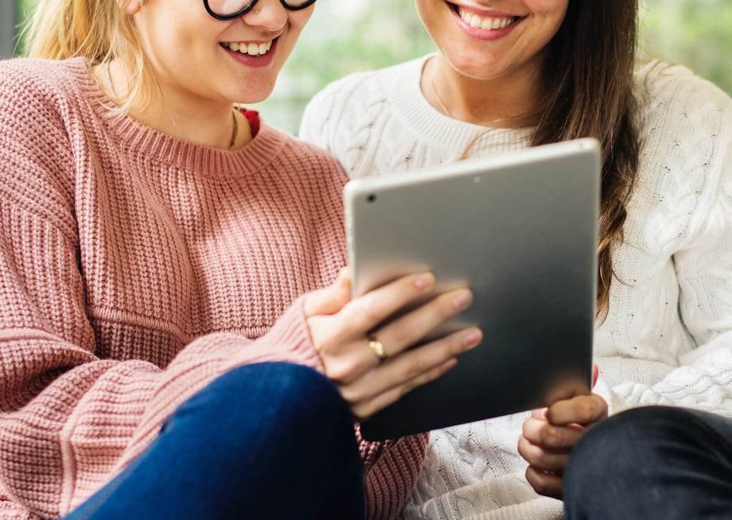meninas usando um tablet e lendo juntas
