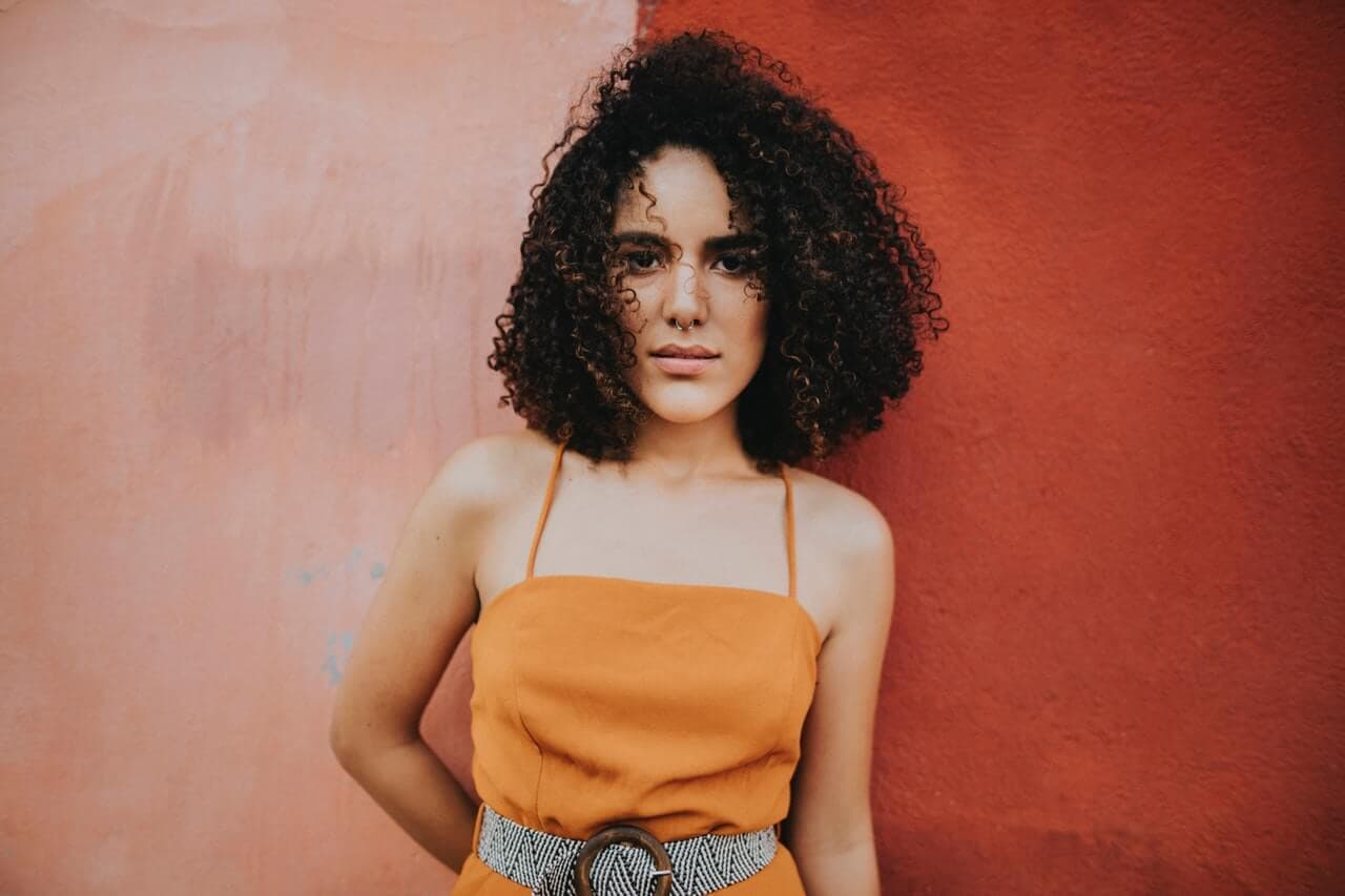 Mulher magra encostada na parede