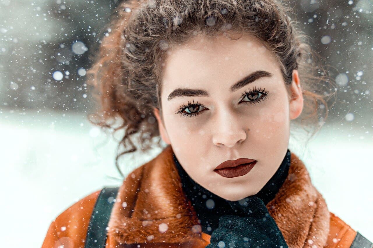 Mulher com roupas de frio na neve