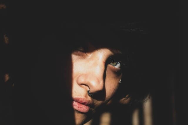 Rosto de uma mulher com luz apenas em parte do rosto