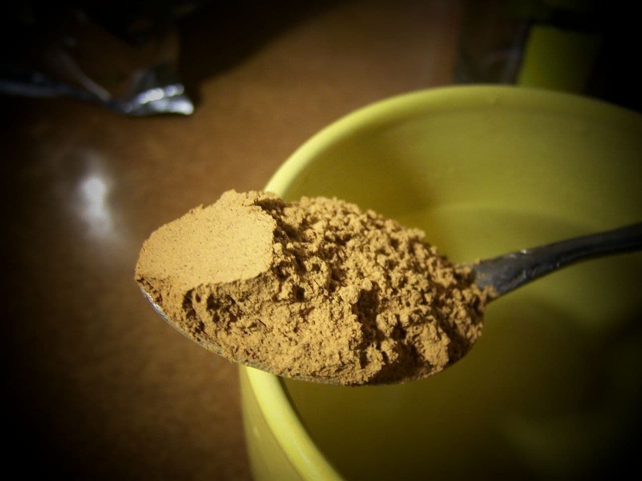 Colher com pó de guaraná, em cima de uma xícara