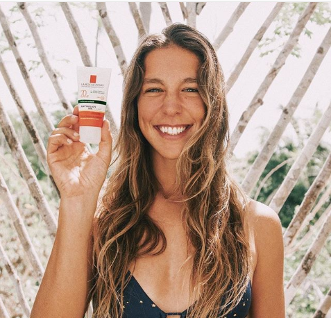 Mulher sorrindo segurando produto la roche