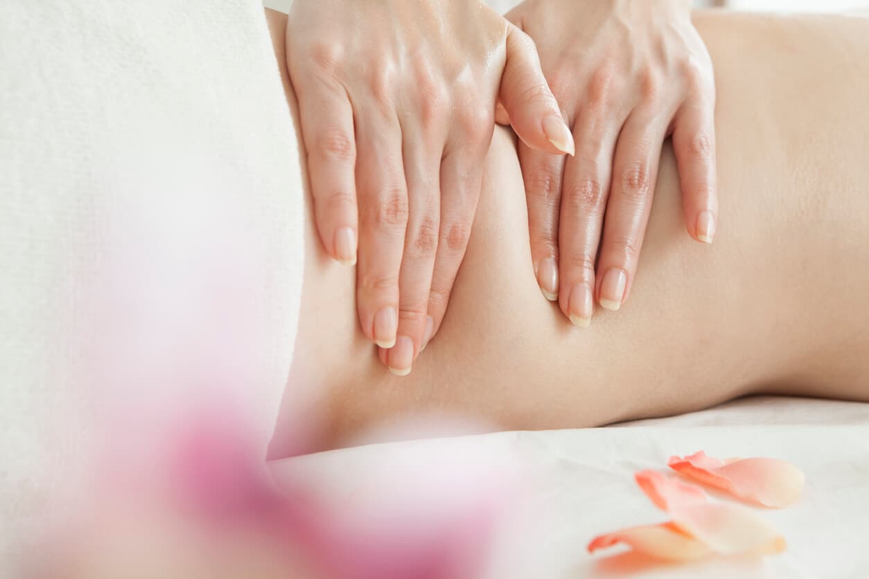 Mulher realizando massagem durante sessão de drenagem linfática.