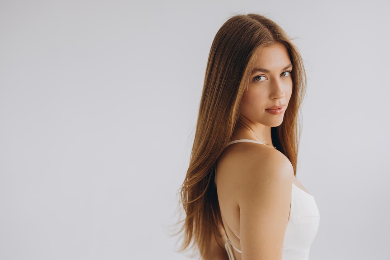 ovem mulher com cabelo castanho longo posando em um fundo branco