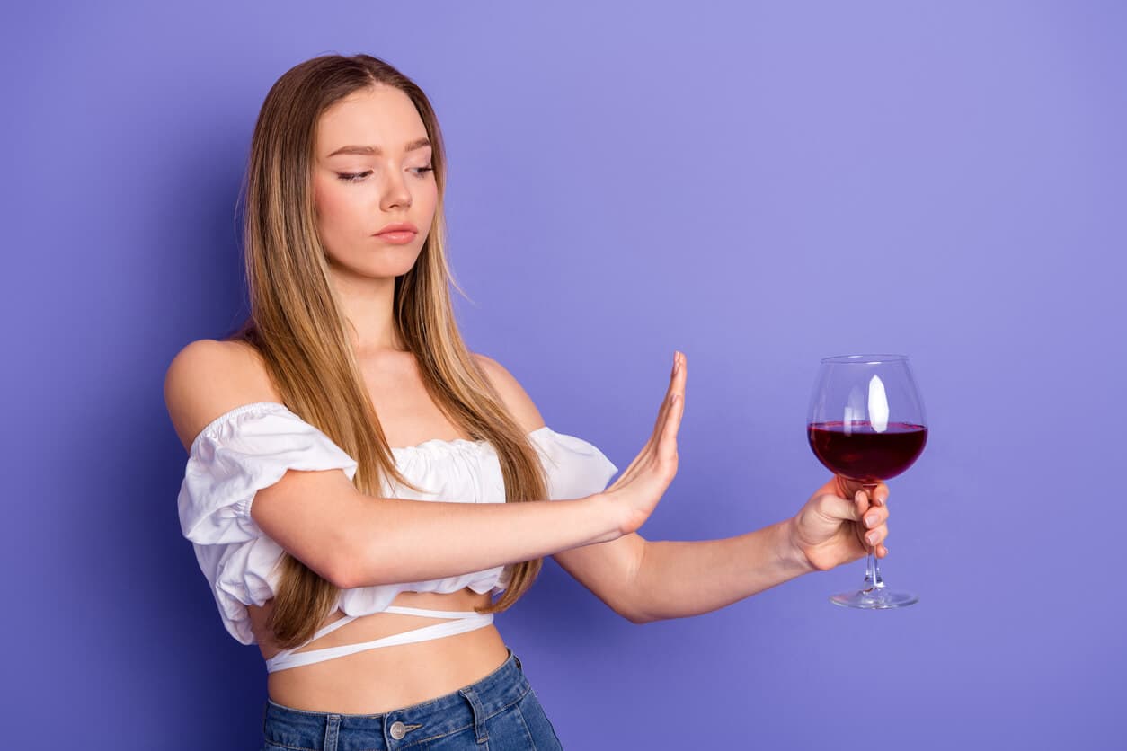 Mulher recusando uma taça de vinho, simbolizando a importância de evitar o consumo de álcool no pós-operatório de cirurgias.