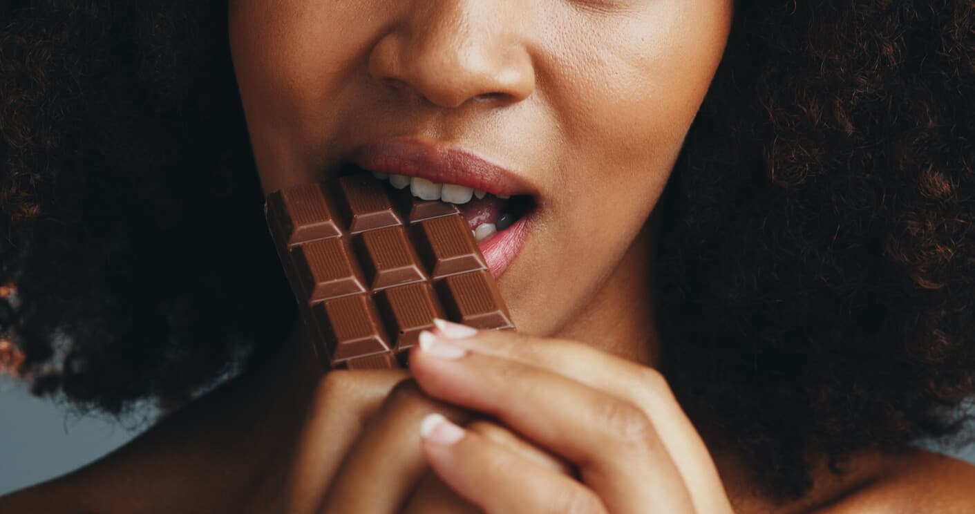 Mulher mordendo barra de chocolate