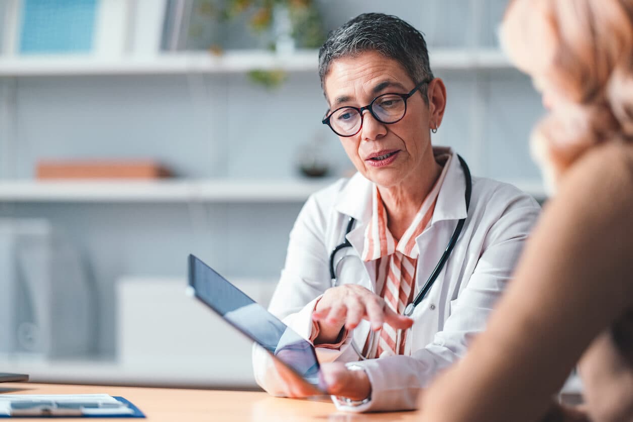 Médica cirurgiã e paciente em consultório durante consulta