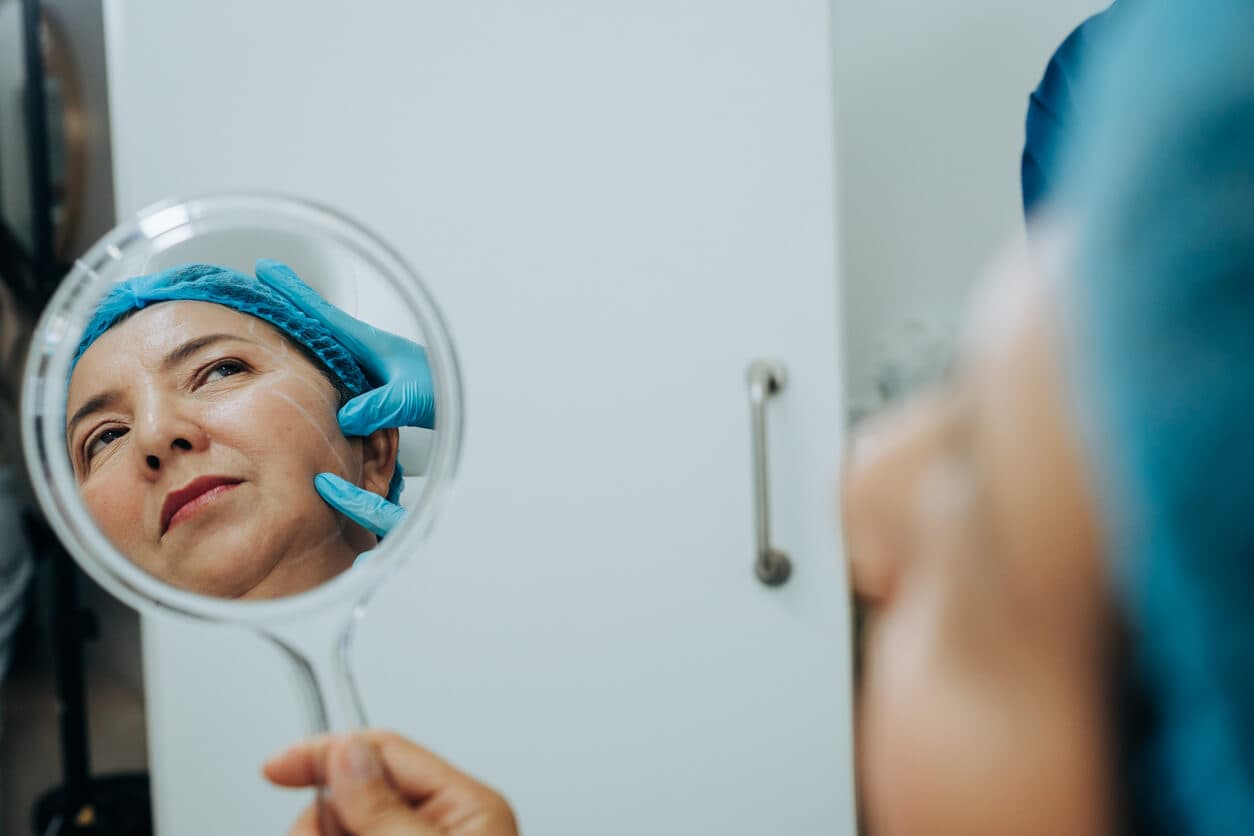 Foco em espelho com o reflexo de uma mulher madura antes do microlifting