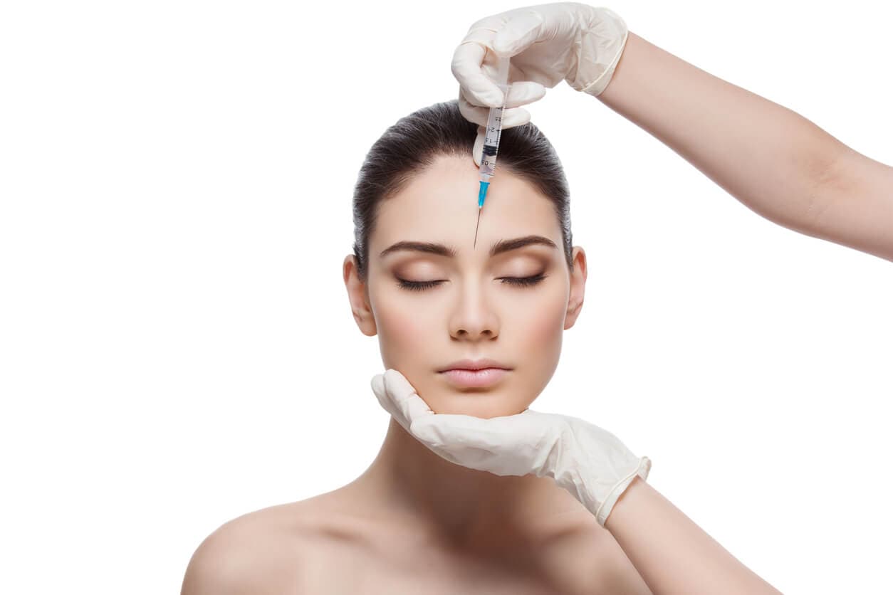Profissional aplicando injeção em paciente durante procedimento estético para rejuvenescimento do rosto.
