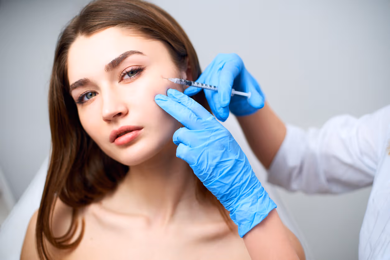 Médico especialista aplicando uma injeção no rosto de uma jovem