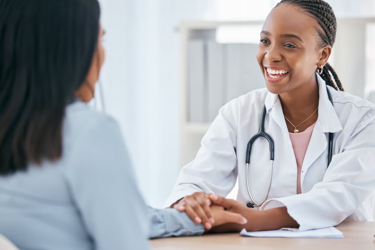 Médica conversa de forma acolhedora com paciente durante consulta sobre cirurgia íntima.