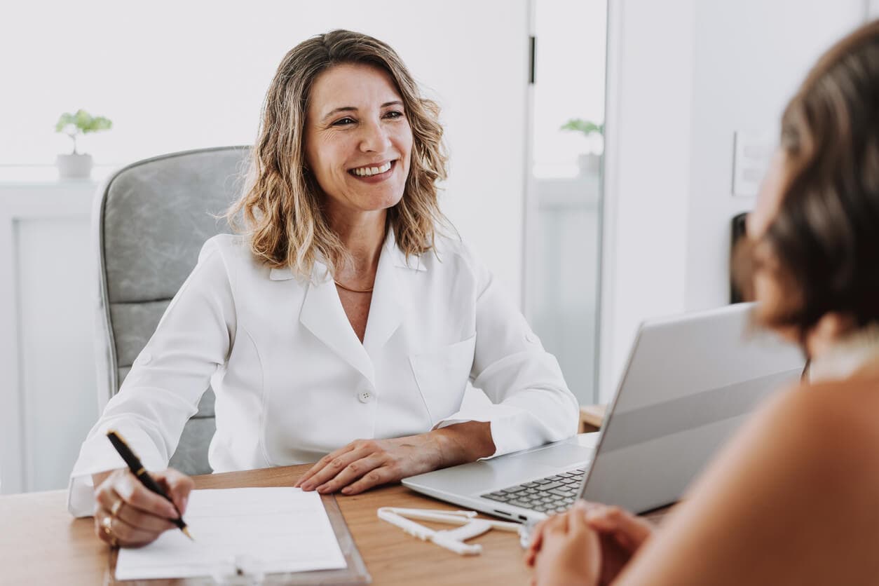 Médica cirurgiã e paciente em consultório durante consulta