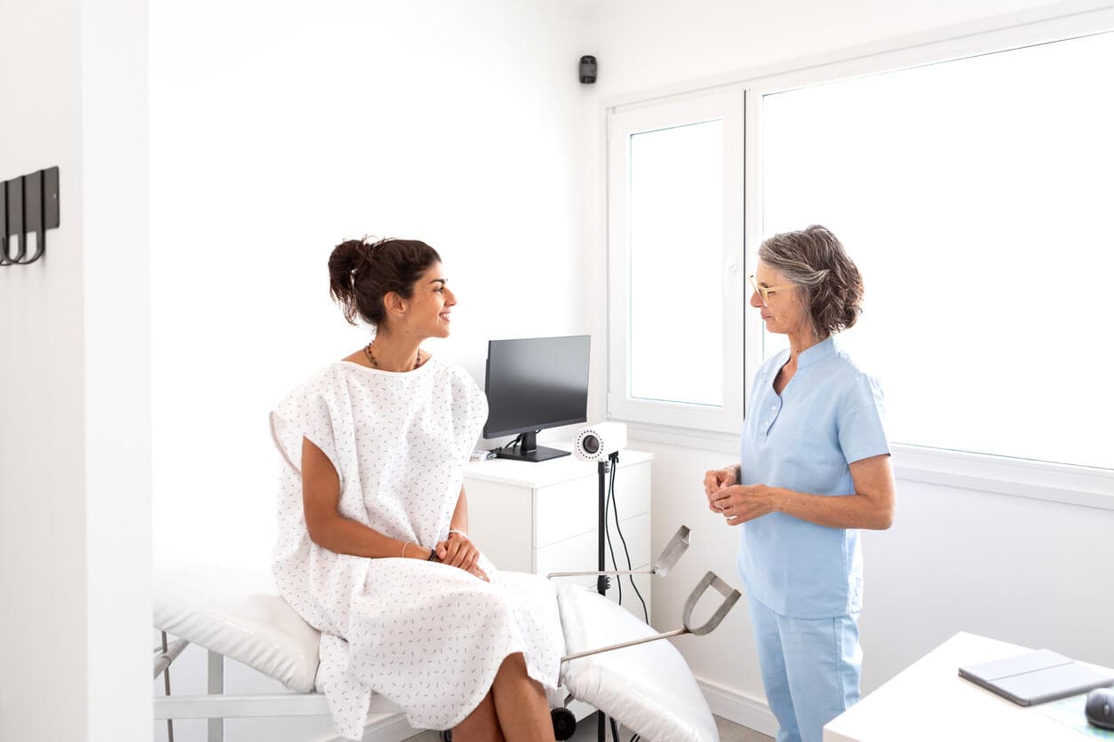 Paciente conversa com médica ginecologista em consultório.