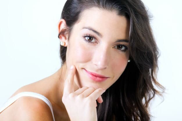 mulher sorrindo com a mão no rosto